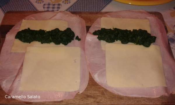 Disporre su ogni fetta di prosciutto 2 fette di formaggio e una cucchiaiata di spinaci lessati