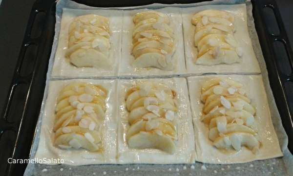Spennellare con la metà della marmellata, unire le lamelle di mandorla e spennellare tutti i bordi con il latte