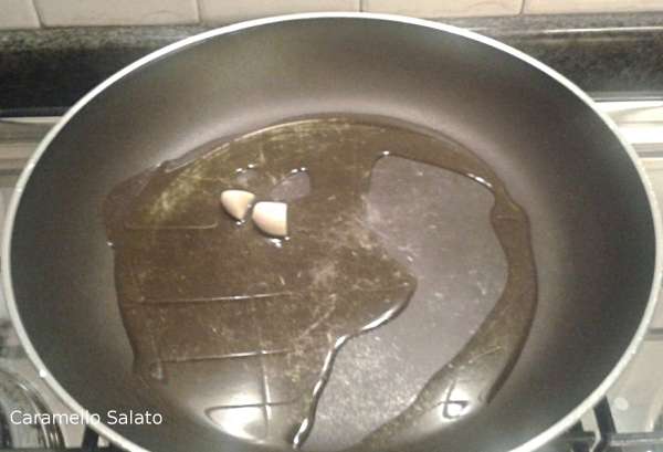In una padella far rosolare l'aglio con l'olio