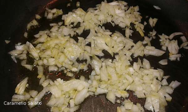 Tagliare finemente la cipolla e farla appassire in un'ampia pentola con 4 cucchiai di olio