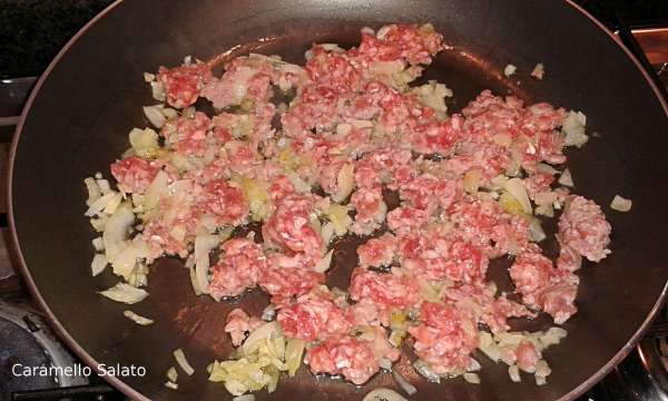 Quando la cipolla sarà appassita aggiungere le salsicce sbriciolate e cuocere una decina di minuti