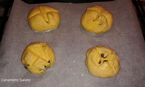 Disporre i 4 panini sulla teglia del forno ricoperta di carta forno, fare un taglio a croce e spennellare con latte tiepido