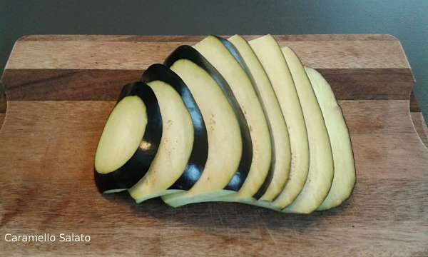 Mentre l'impasto della pizza lievita dedicatevi alla farcitura. Lavate la melanzana e tagliatela in fette da circa 1 cm. l'una