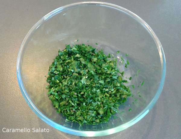 Lavare il prezzemolo, sgocciolarlo e tritarlo finissimo assieme all'aglio