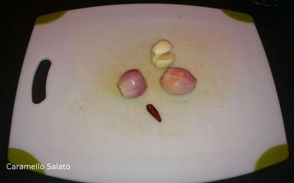 Mondare gli scalogni, gli spicchi di aglio e il peperoncino