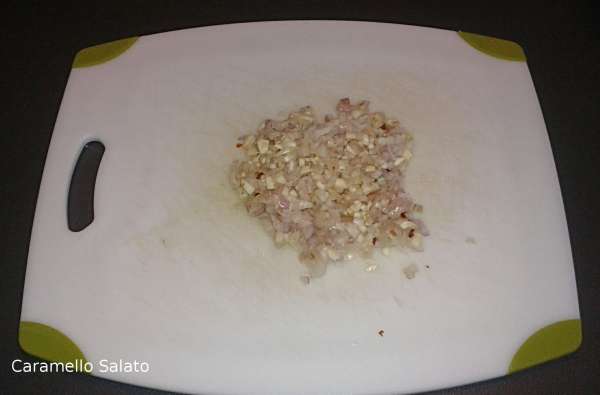 Tritare insieme il peperoncino, gli spicchi di aglio, gli scalogni