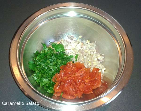 In una ciotola radunare il trito di prezzemolo, i pomodorini e il trito di scalogno, aglio e peperoncino 