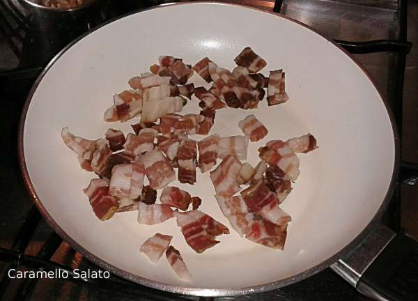 Tagliare la pancetta affumicata a dadini e farla cuocere per una decina di minuti in un pentolino a parte, lasciar raffreddare anche la pancetta