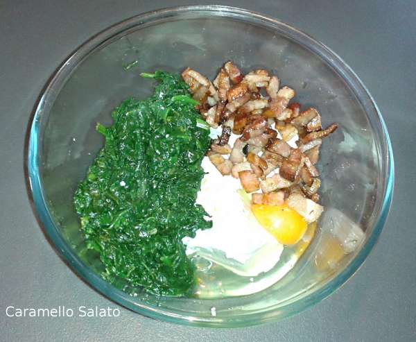 In una ciotola disporre gli spinaci, la pancetta, la ricotta, l'uovo, il parmigiano, sale e pepe