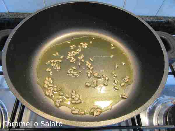 Mettere l'olio in una pentola e farlo scaldare aggiungere i semi di girasole, da quando iniziano a sfrigolare calcolare 1 minuto