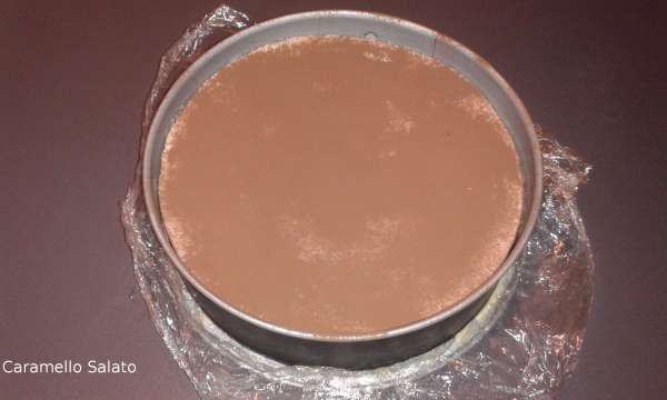 Una volta rassodato estrarre il dolce, versare il cacao amaro facendolo passare attraverso un colino, passare la lama del coltello tutto intorno al cerchio, aprire il cerchio e disporre il semifreddo sul piatto di portata