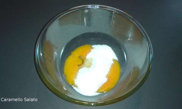 Dividere i tuorli dagli albumi e metterli in 2 ciotole separate. Mettere metà dello zucchero nei tuorli e montare con lo sbattitore