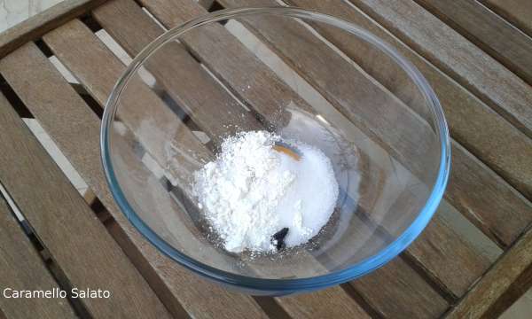 Mettere in un contenitore adatto al microonde zucchero, amido, il tuorlo, i semi della bacca di vaniglia